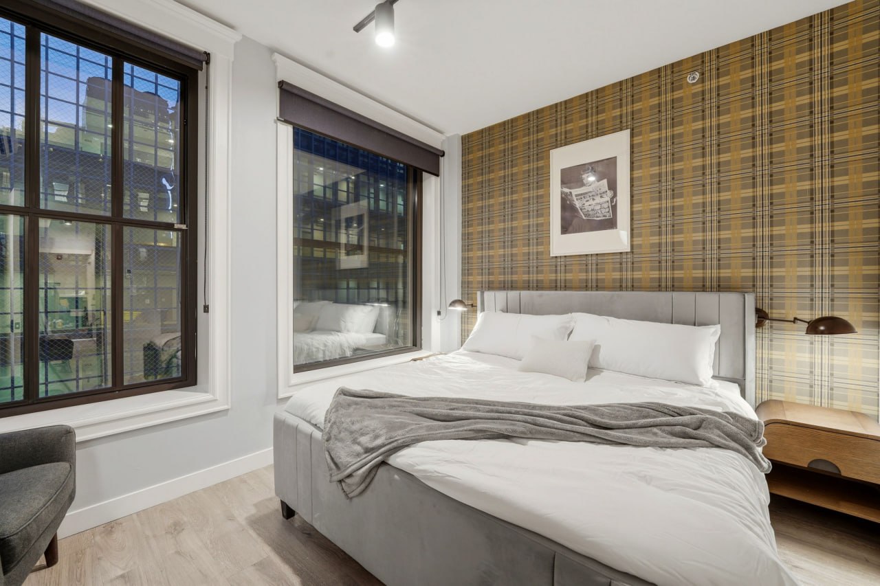 Plaid wallpaper bedroom with king bed and city views