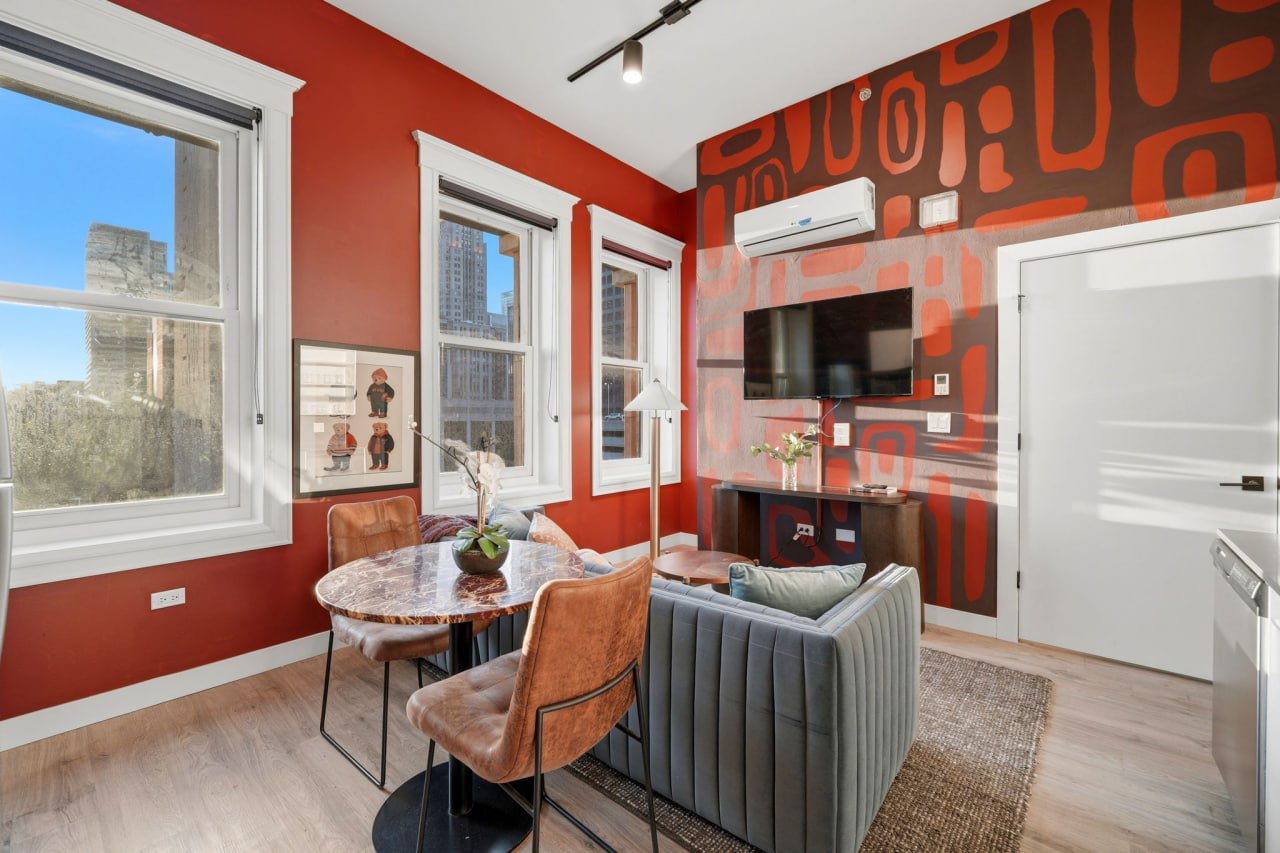 Red and brown abstract mural with dining area and kitchen visible